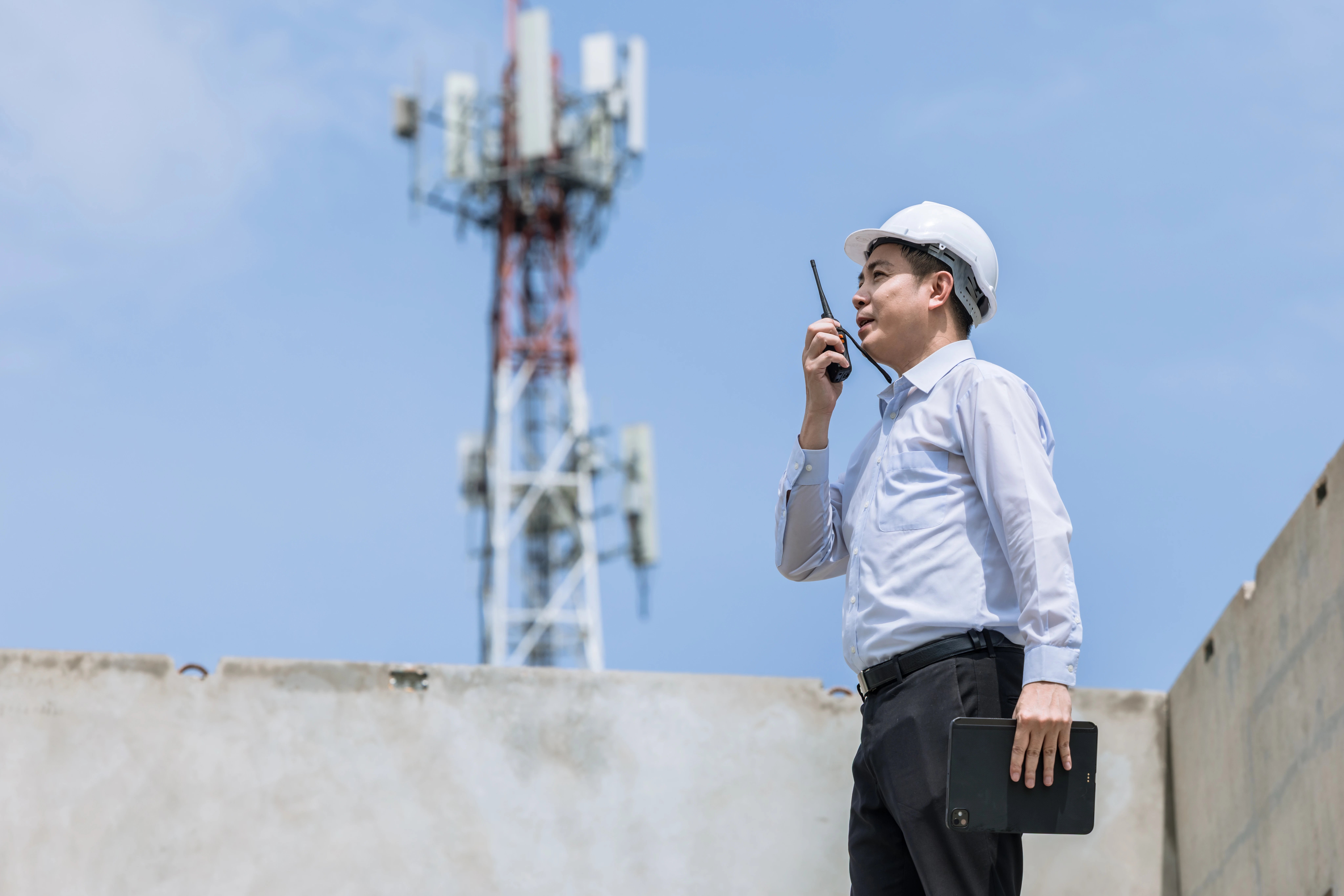 engineer-working-with-radio-near-cellular-tower-2026-03-25-03-20-53-utc
